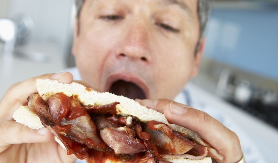 man eating a bacon sandwich