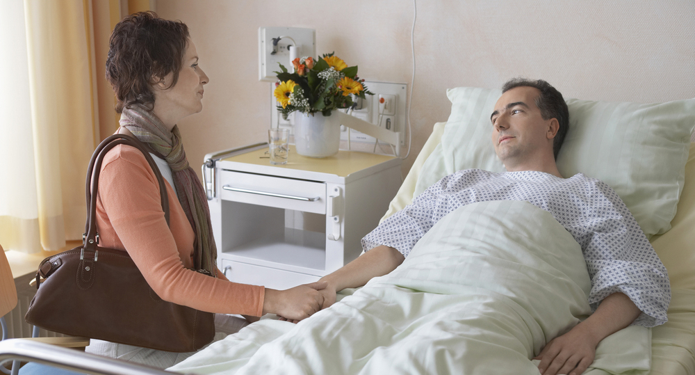 woman visiting patient in hospital bed - spinal cord injury