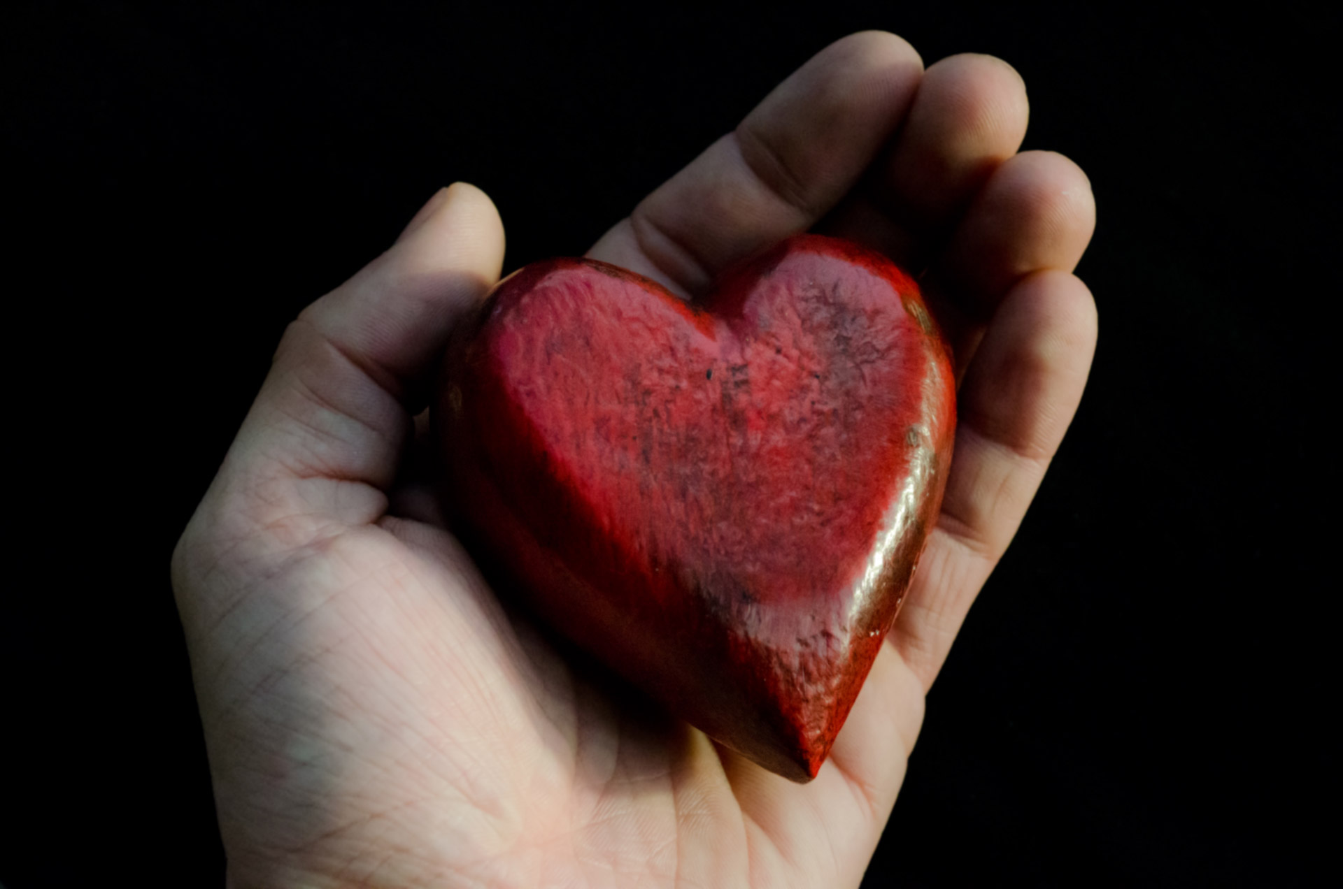 Hand holding red stone heart